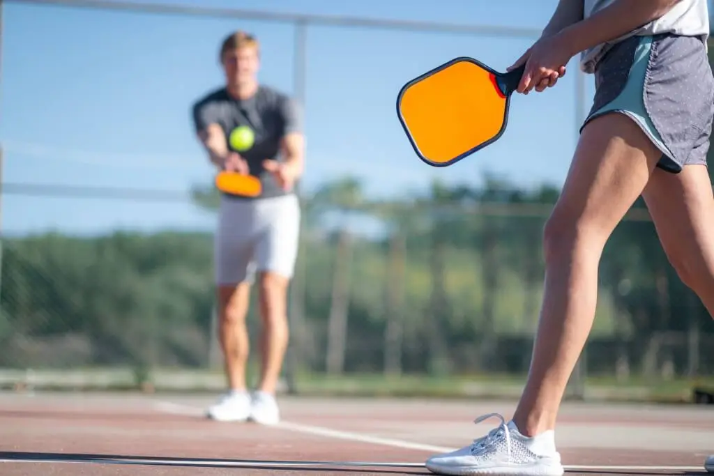 Two pickleball players on court, illustrating common pickleball injuries and prevention